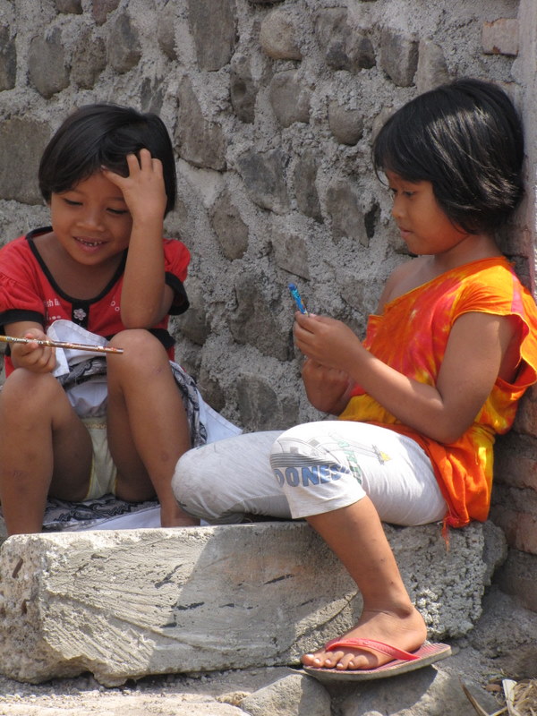 Passing out pencils to some  children in the local village